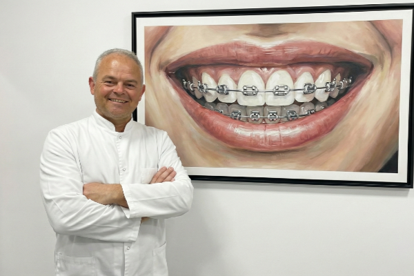 Mauro Grau vor einer Abbildung, die Brackets zeigt